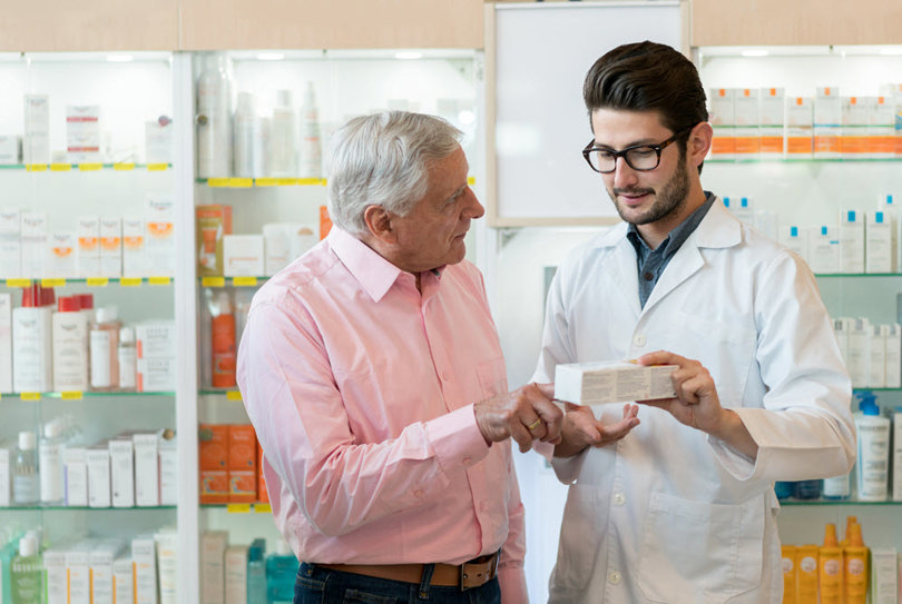 Pharmacist helping man about medication