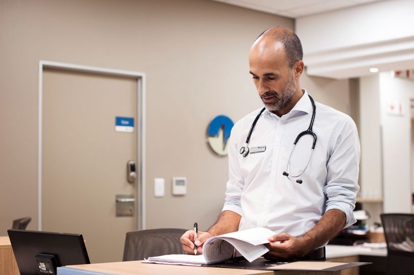 Physician writing in a chart