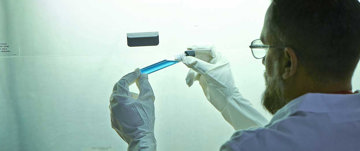 Man looking at blue vial.