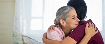 Nurse hugging an elderly woman.