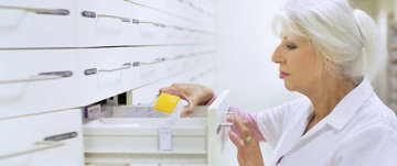 Pharmacist taking medicine from a drawer