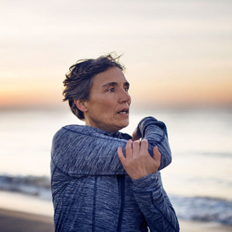 Woman stretching on the beach.